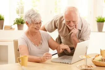 Elderly couple look at a laptop