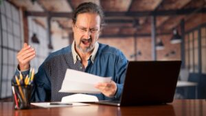 Angry man realizing he lost money to investor fraud. A Manhattan Beach lawyer can help you obtain compensation and peace of mind after losing money to investment fraud.