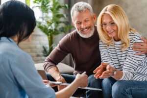 a middle-aged couple meeting with an Orange investment fraud lawyer