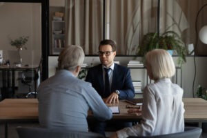An investment loss recovery lawyer in Georgia reviewing legal options with his senior clients.