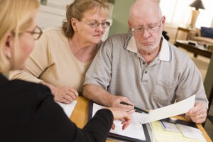 An investment loss recovery lawyer in New York reviewing legal options with her senior clients.