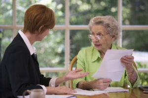 An investment loss recovery lawyer in Texas reviewing legal options with her elderly client.
