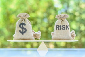 Dollar and risk bags on a balance scale depict the evaluation of financial risk. If a financial advisor betrayed your trust, an Arizona Ponzi scheme lawyer will help you hold the at-fault party accountable.