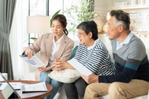 An elderly couple talks with a financial advisor about the risks of whole life insurance.