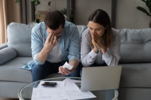 Young man and woman looking frustrated and upset because they realize that they may be the victims of Newbridge Securities Corporation fraud.