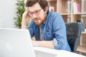 Person looking at a laptop screen and worried about what to do since their Binance account was hacked