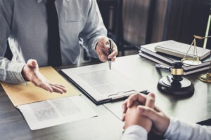 Lawyer sits at desk with client and explains whether they can file a lawsuit against Kraken.