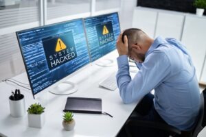 A man at a computer realizes his system has been compromised and wonders what to do if his Robinhood account was hacked.  