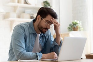 Person sitting in front of a laptop and worried about what to do after their Fidelity Crypto account was hacked